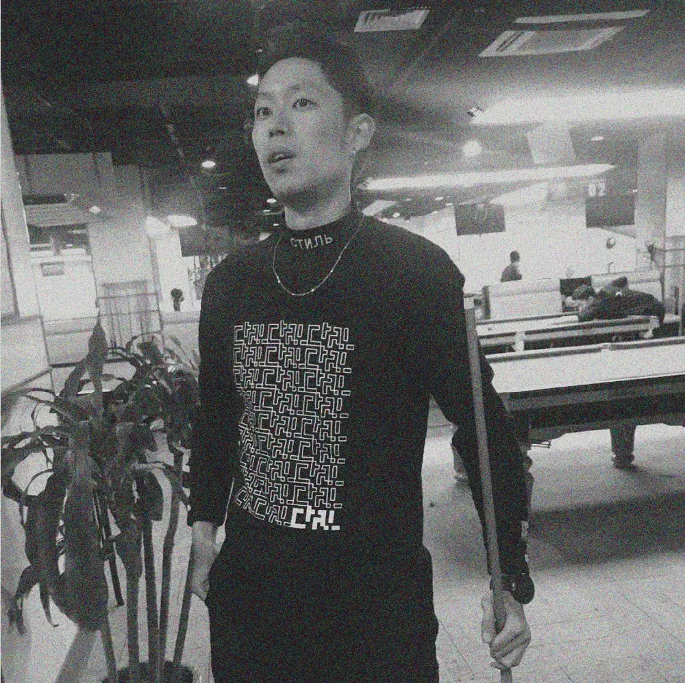 A man wearing the T-shirt printed with the logo pattern.